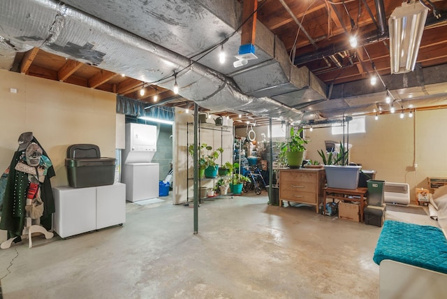 below grade area with concrete block wall and stacked washer and clothes dryer