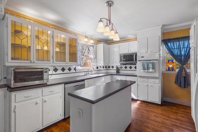 kitchen featuring crown molding, decorative backsplash, dark countertops, and stainless steel appliances