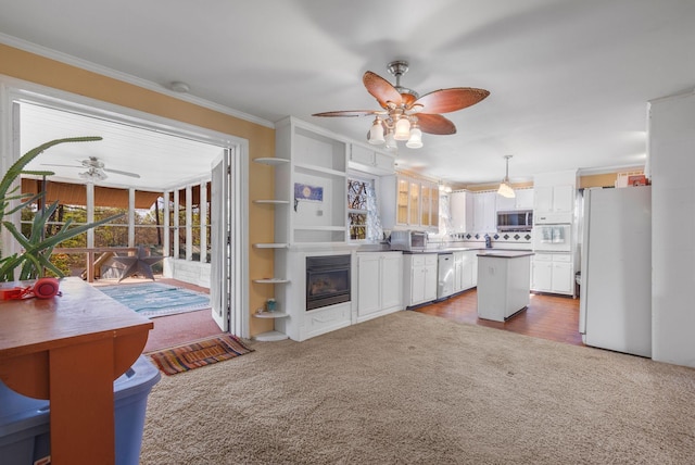 kitchen featuring stainless steel microwave, dark colored carpet, freestanding refrigerator, a ceiling fan, and dishwasher