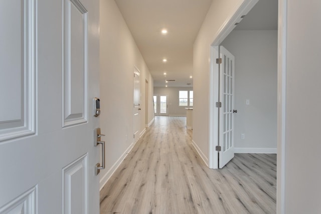 hall featuring french doors, baseboards, light wood finished floors, and recessed lighting