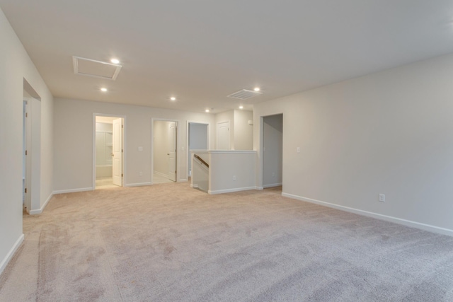 unfurnished room featuring light colored carpet, visible vents, recessed lighting, attic access, and baseboards
