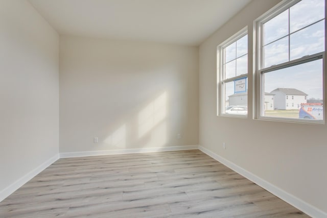 unfurnished room with light wood-style floors and baseboards
