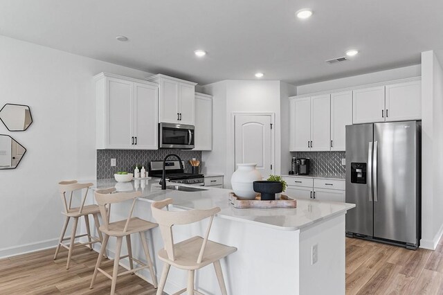 8547 Turnbull Dr, Pleasant View, TN 37146 - kitchen with stainless steel appliances, a peninsula, light countertops, a breakfast bar, and recessed lighting