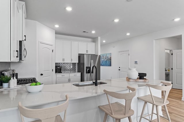 8547 Turnbull Dr, Pleasant View, TN 37146 - kitchen featuring stainless steel appliances, tasteful backsplash, a kitchen bar, a peninsula, and recessed lighting