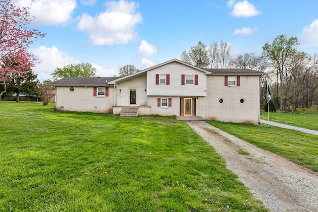 view of front of house with brick siding, a front lawn, and dirt driveway