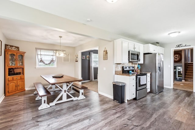 kitchen with dark wood-type flooring, white cabinetry, baseboards, and appliances with stainless steel finishes