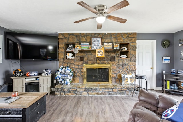 living room featuring wood finished floors, ceiling fan, and a fireplace