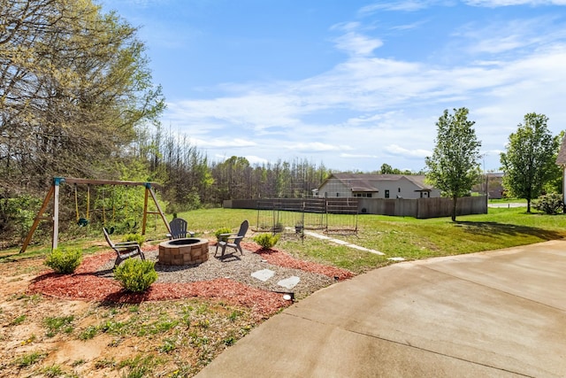 view of yard with an outdoor fire pit, a playground, and fence
