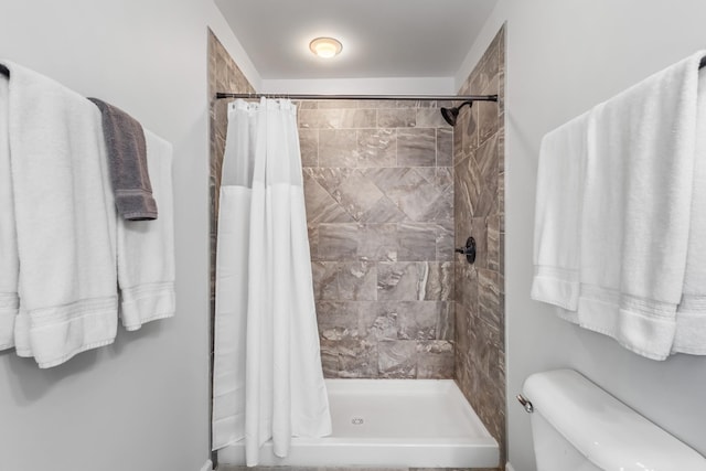 bathroom with a shower stall and toilet