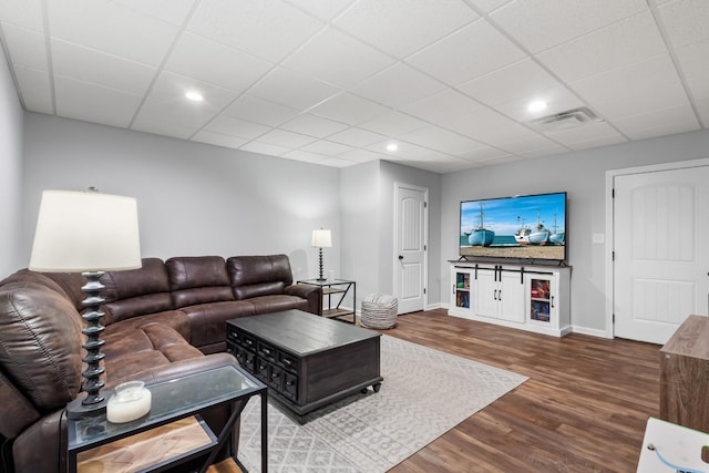 living room featuring a paneled ceiling, visible vents, recessed lighting, baseboards, and dark wood-style floors