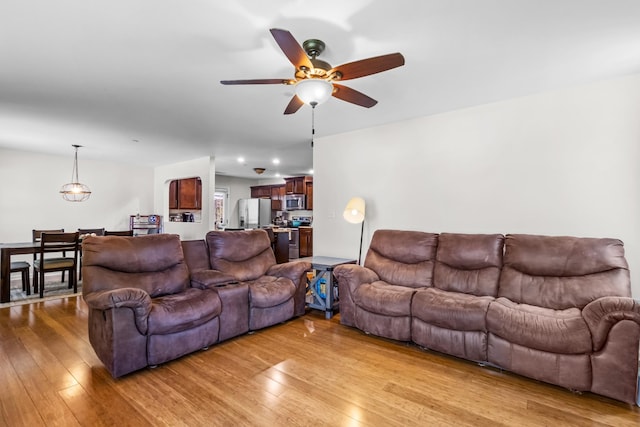 living area featuring light wood-style flooring and ceiling fan