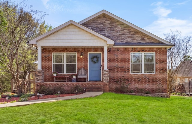 bungalow-style house featuring brick siding, a front lawn, and a porch