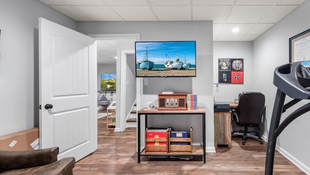 home office featuring baseboards, recessed lighting, a drop ceiling, and wood finished floors