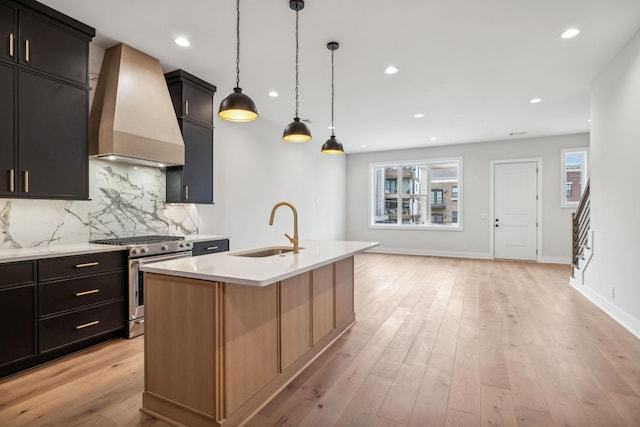 3207B Long Blvd, Nashville, TN 37203 - kitchen featuring custom exhaust hood, backsplash, stainless steel range with gas cooktop, a center island with sink, and a sink