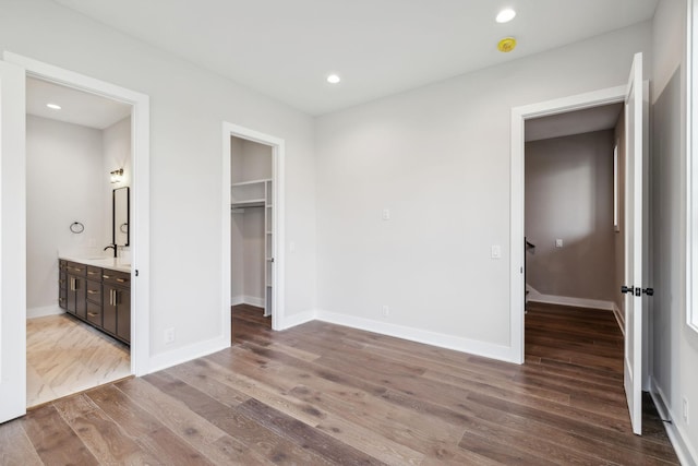 3207A Long Blvd, Nashville, TN 37203 - unfurnished bedroom featuring baseboards, recessed lighting, a walk in closet, a sink, and wood finished floors