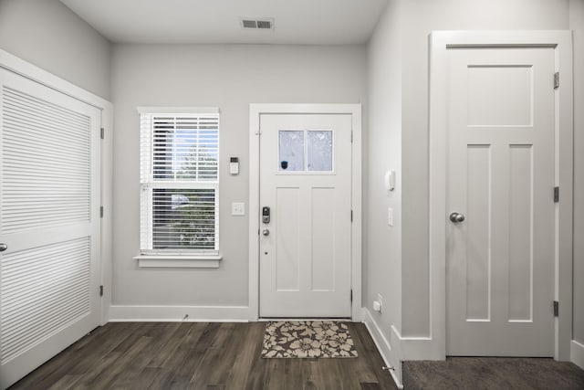 foyer featuring visible vents, dark wood-style flooring, and baseboards