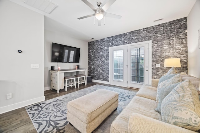 living room with baseboards, a ceiling fan, wood finished floors, and visible vents