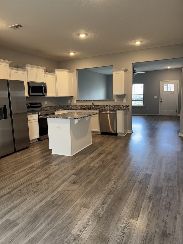 kitchen featuring dark wood-type flooring, visible vents, white cabinetry, and appliances with stainless steel finishes
