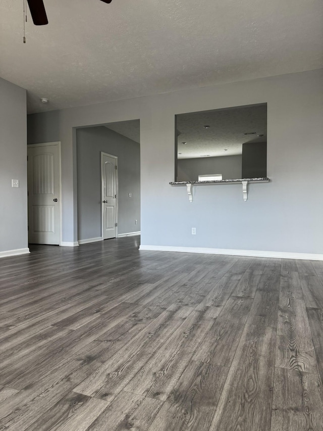 spare room featuring dark wood-style floors, baseboards, and ceiling fan