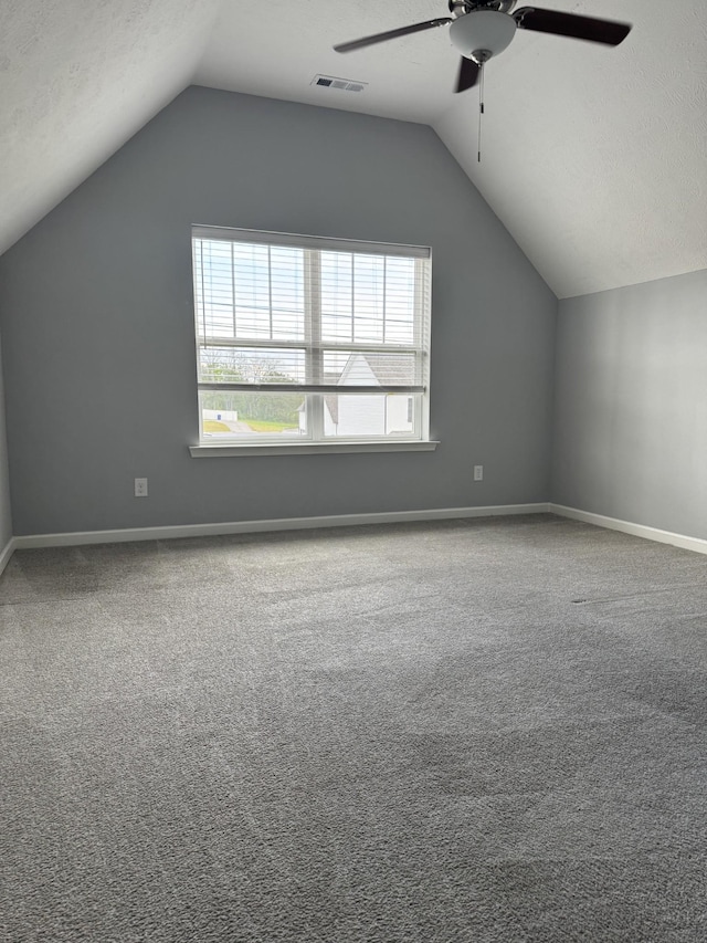 additional living space featuring vaulted ceiling, a ceiling fan, visible vents, and carpet floors