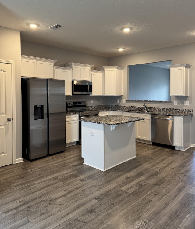 kitchen featuring a center island, dark wood finished floors, white cabinetry, and stainless steel appliances