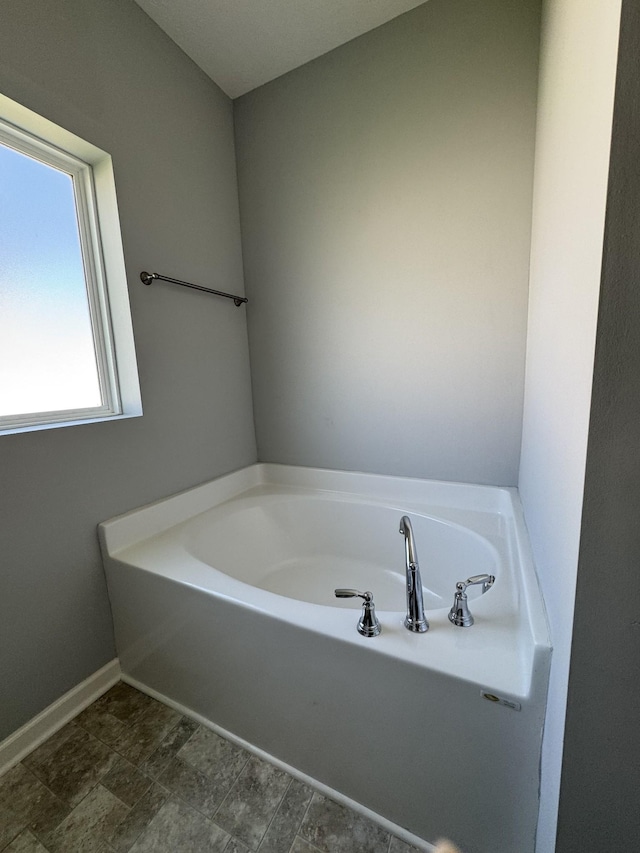 full bathroom with baseboards and a garden tub
