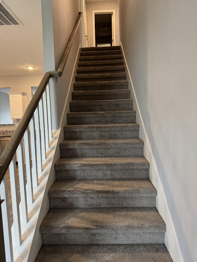 stairs featuring carpet flooring and visible vents