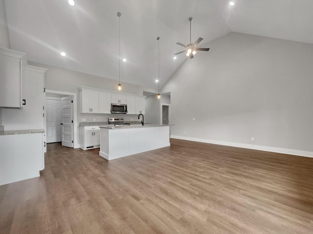 4 Young Branch Rd, Dixon Springs, TN 37057 - kitchen with stainless steel microwave, range with electric stovetop, open floor plan, an island with sink, and recessed lighting