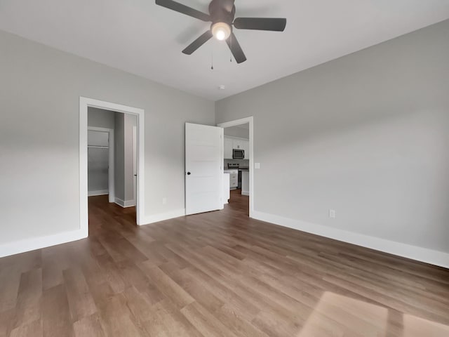 4 Young Branch Rd, Dixon Springs, TN 37057 - unfurnished bedroom with a walk in closet, wood finished floors, and a ceiling fan