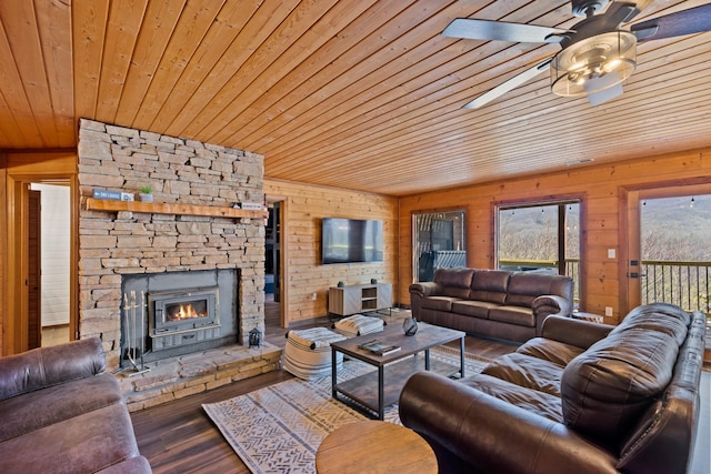 living area featuring a fireplace, wooden walls, a ceiling fan, wood ceiling, and wood finished floors