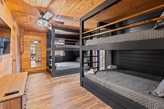 bedroom with wood walls, wooden ceiling, and wood finished floors