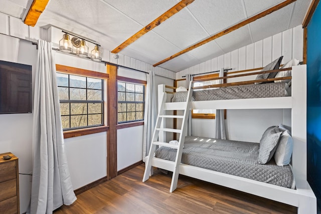 bedroom with wood finished floors and lofted ceiling with beams