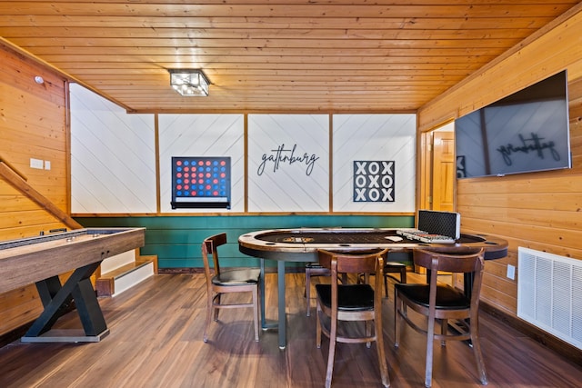 playroom with wooden walls, visible vents, wooden ceiling, and wood finished floors
