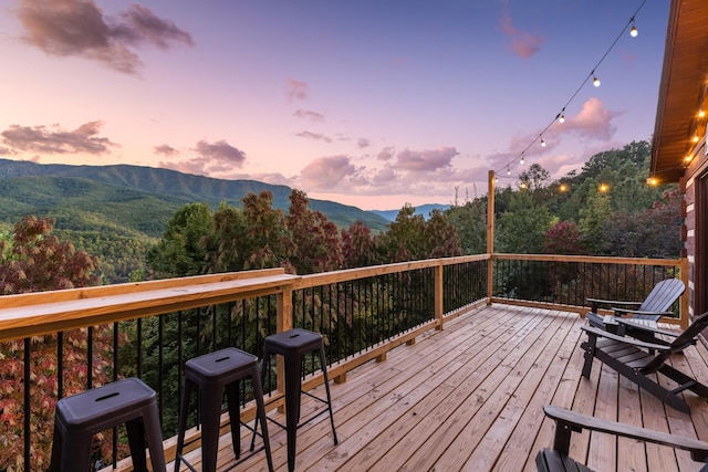 deck at dusk featuring a mountain view
