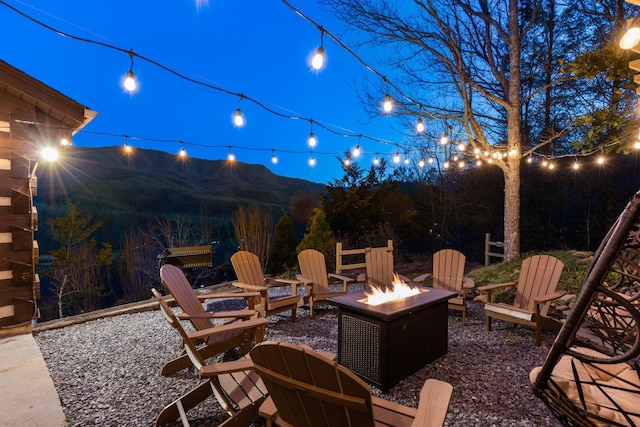 patio at night with a fire pit and a mountain view