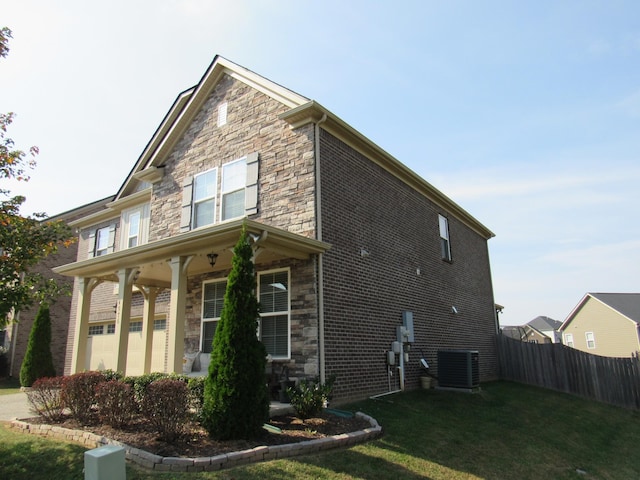 view of side of property featuring central air condition unit, a yard, a porch, fence, and stone siding
