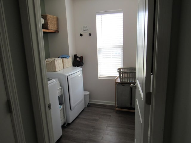 washroom featuring laundry area, separate washer and dryer, baseboards, and dark wood-style floors