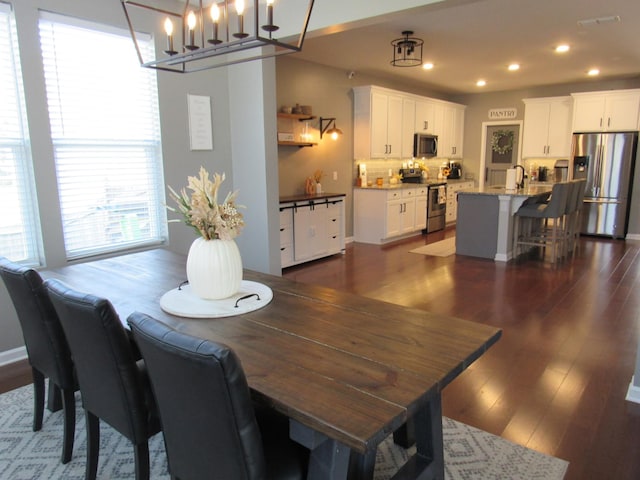 dining space with recessed lighting, dark wood-type flooring, visible vents, and an inviting chandelier