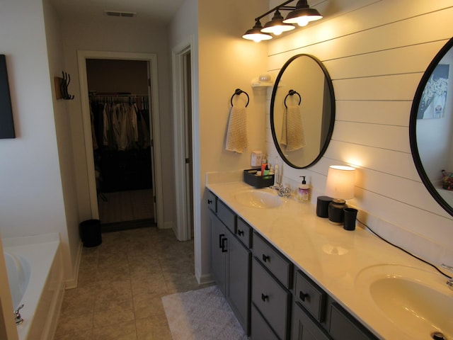 full bath featuring tile patterned floors, a sink, a spacious closet, and visible vents
