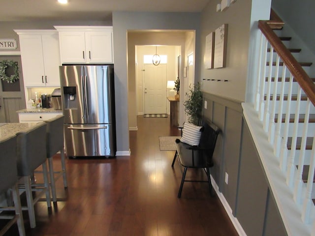 kitchen with dark wood-type flooring, white cabinets, recessed lighting, stainless steel refrigerator with ice dispenser, and light stone counters