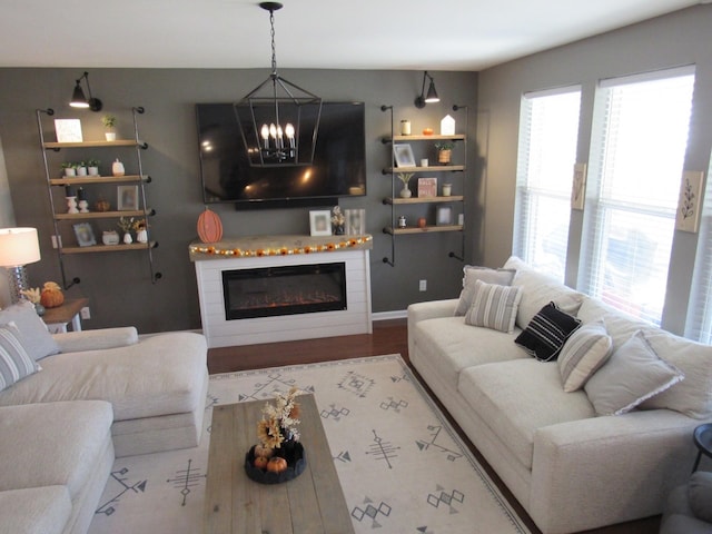 living area with a glass covered fireplace and an inviting chandelier