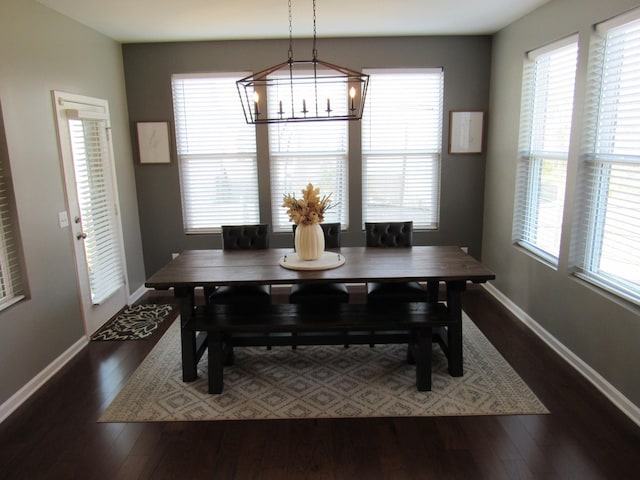 dining space with a notable chandelier, dark wood finished floors, and plenty of natural light