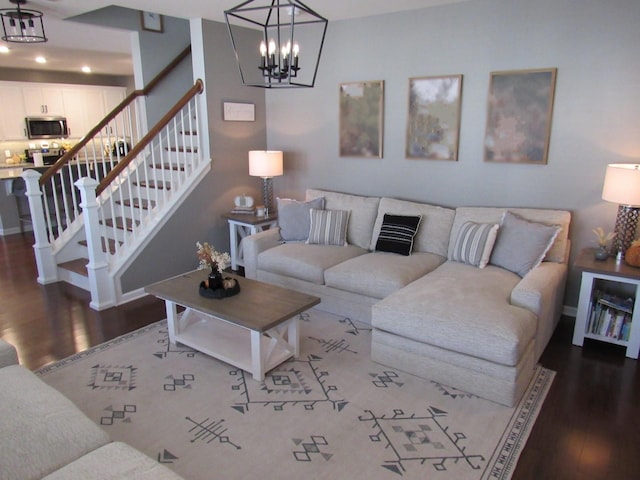 living room featuring wood finished floors, a notable chandelier, and stairs