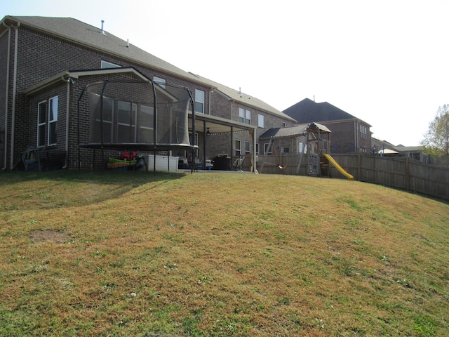 view of yard featuring fence, a sunroom, and a playground