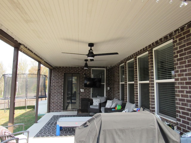 view of patio / terrace with fence, an outdoor living space, and a ceiling fan