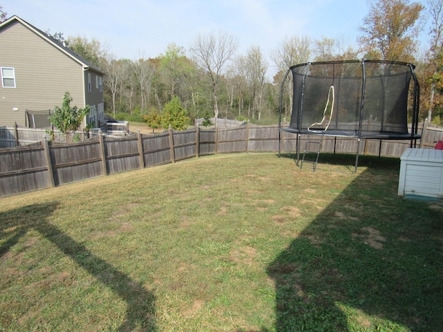 view of yard with fence and a trampoline