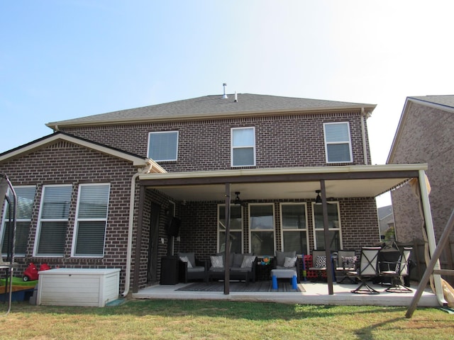 back of house featuring a patio, brick siding, a yard, and a ceiling fan