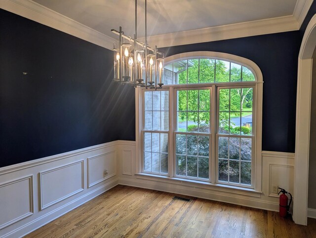 8208 Boxmere Ct, Brentwood, TN 37027 - unfurnished dining area with a chandelier, crown molding, wainscoting, wood finished floors, and a decorative wall