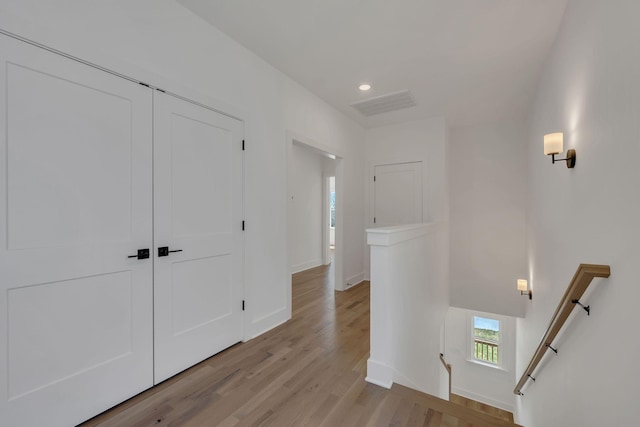 hallway featuring visible vents, recessed lighting, an upstairs landing, light wood finished floors, and baseboards