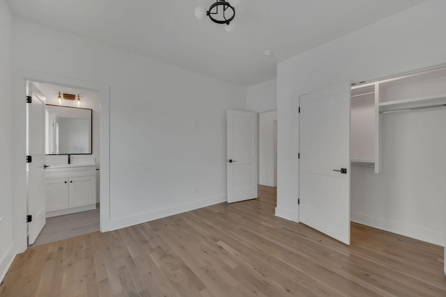 unfurnished bedroom featuring a closet, light wood finished floors, and baseboards